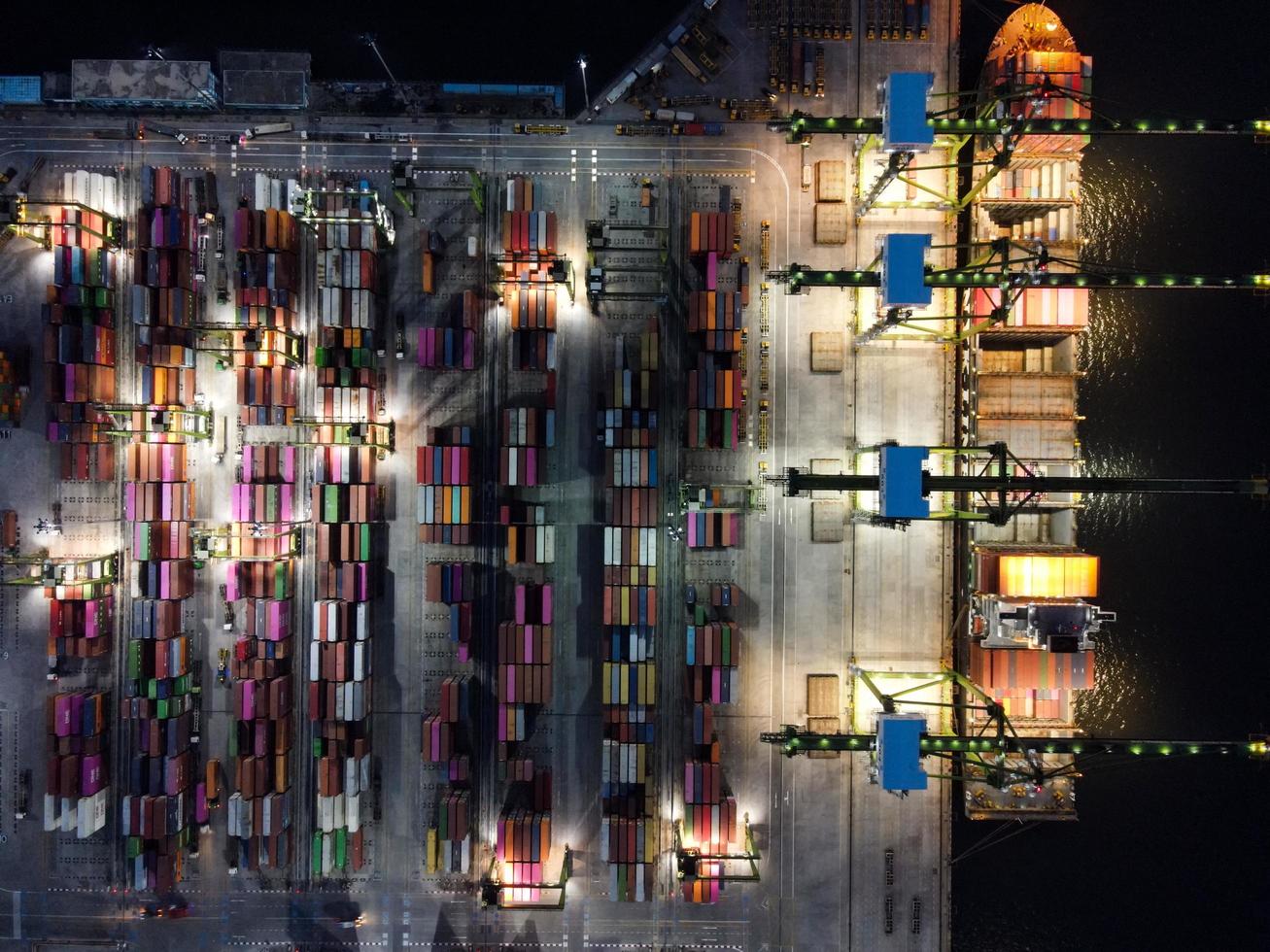 Jakarta, Indonesië 2021 - luchtfoto van het laden en lossen van containerschepen in de diepzeehaven, logistieke import en export van vrachtvervoer per containerschip op open zee 's nachts foto