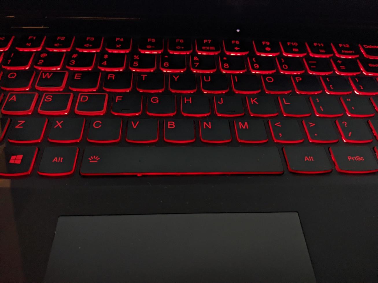 toetsenbord met rood achtergrondverlichting sms'en door hand. de foto is geschikt naar gebruik voor laptop achtergrond werkzaamheid en onderhoud inhoud media.