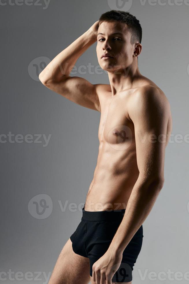 bodybuilder geschiktheid Mens met een opgewonden torso hand- achter hoofd grijs achtergrond model- foto