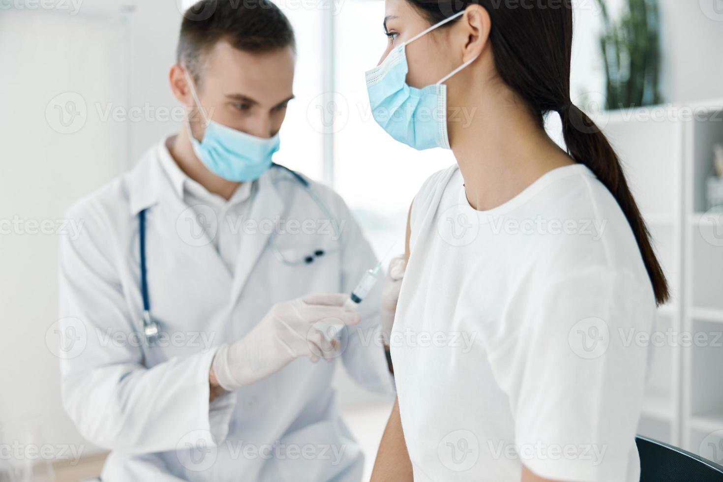 dokter in een medisch japon en een beschermend masker injectiespuit infectie vaccin ampul laboratorium ziekenhuis foto