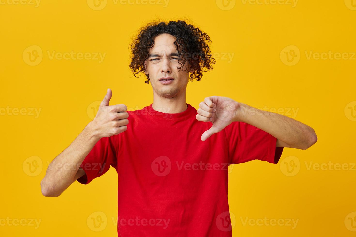 ontevreden grappig Kaukasisch jong Mens in rood t-shirt tonen dis Leuk vinden gebaar poseren geïsoleerd Aan geel studio achtergrond. de het beste aanbod met vrij plaats voor reclame. emoties voor elke dag concept foto