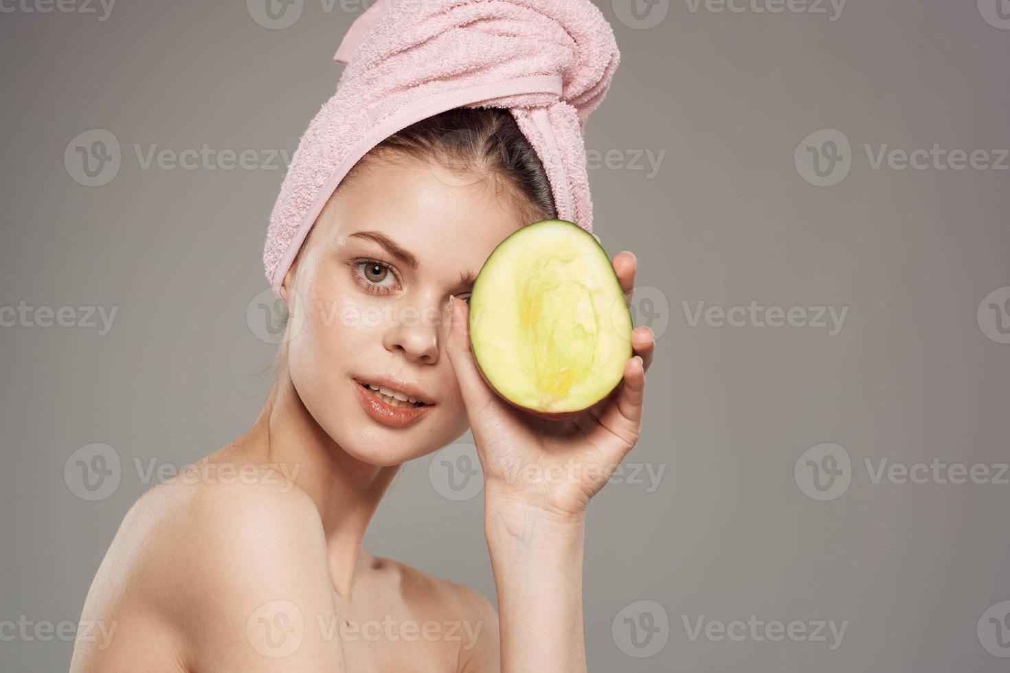 glimlachen vrouw met kaal schouders met handdoek Aan hoofd mango in hand- bijgesneden visie foto