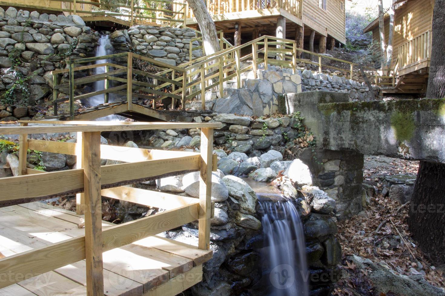 waterval in de park. water watervallen naar beneden de trap. waterval in de Woud met houten trap en leuningen in de bergen foto
