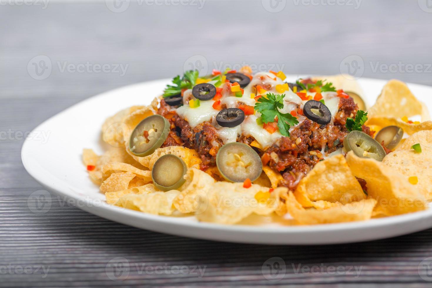Mexicaans beroemd voedsel pittig grond rundvlees nacho's. verwarmde knapperig tortilla chips met gesmolten kaas en jalapeno geserveerd een tussendoortje voedsel. foto