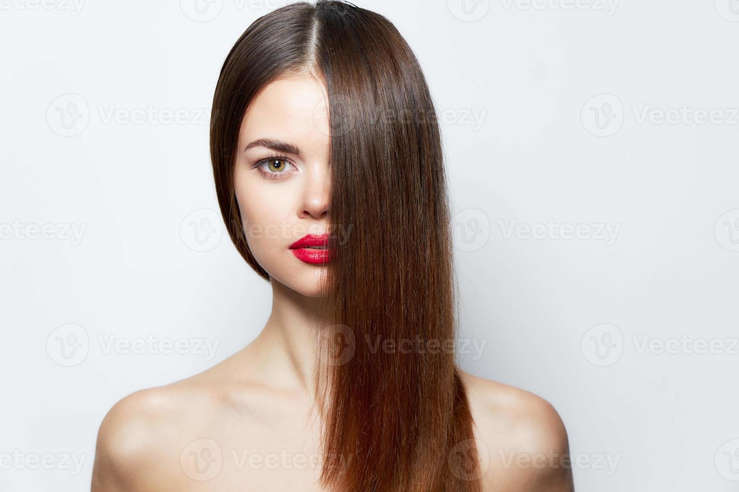charmant vrouw naakt schouders rood lippen haar- aan het bedekken gezicht huid zorg licht foto