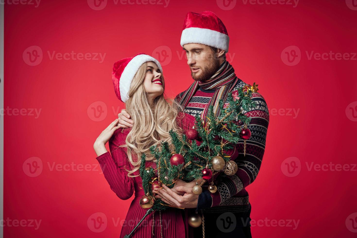 portret van een jong paar in een omhelzing vakantie Kerstmis rood achtergrond foto