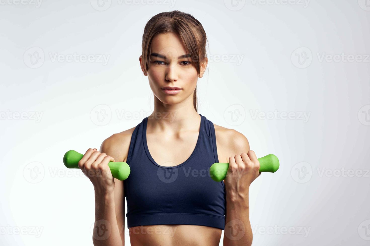 vrouw met groen halters werken uit in de Sportschool motivatie geschiktheid foto