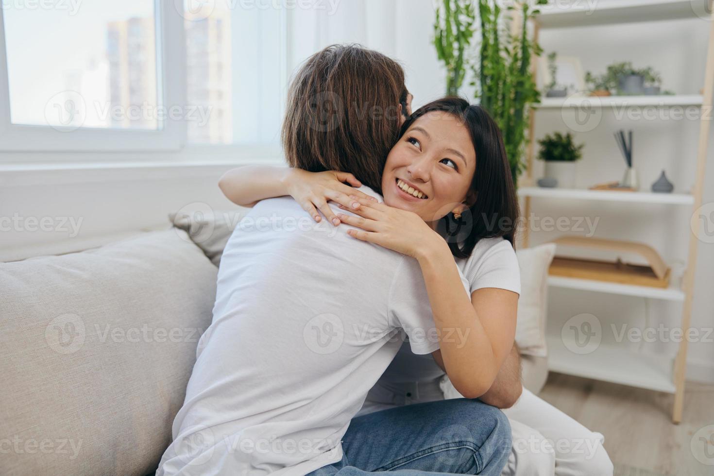 een Aziatisch vrouw knuffels haar man en glimlacht. de vreugde van gebruik makend van de familie en de mooi zo psychologisch staat na de ruzie foto