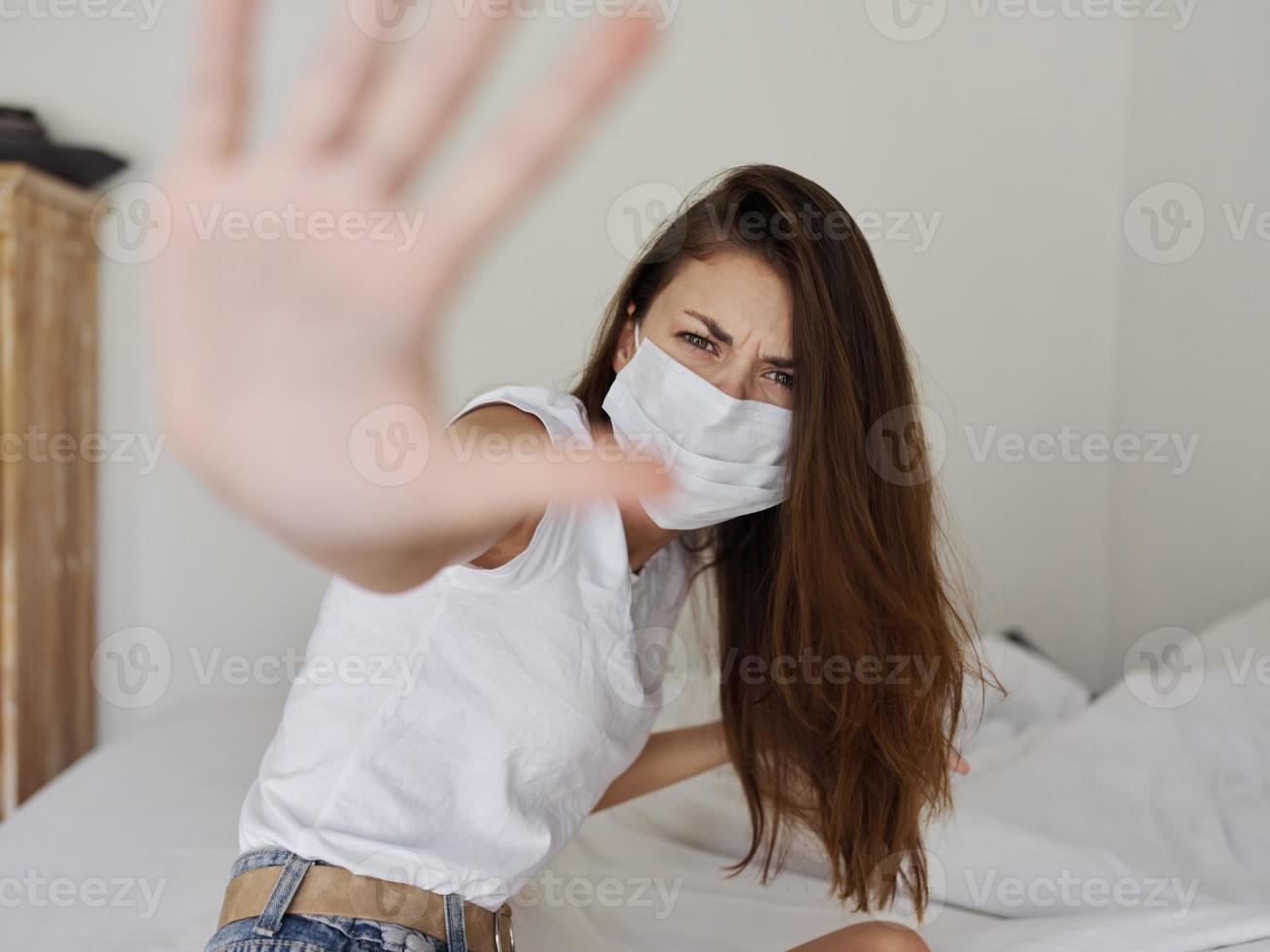 vrouw vervelend medisch masker prikkelbaarheid quarantaine coronavirus pandemisch aan het bedekken gezicht met palm foto