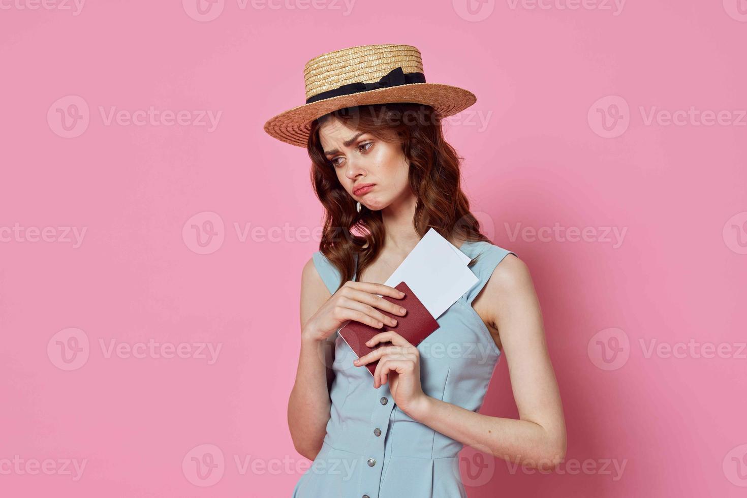 vrouw met hoed paspoort en vlak ticket luchthaven passagier roze achtergrond foto