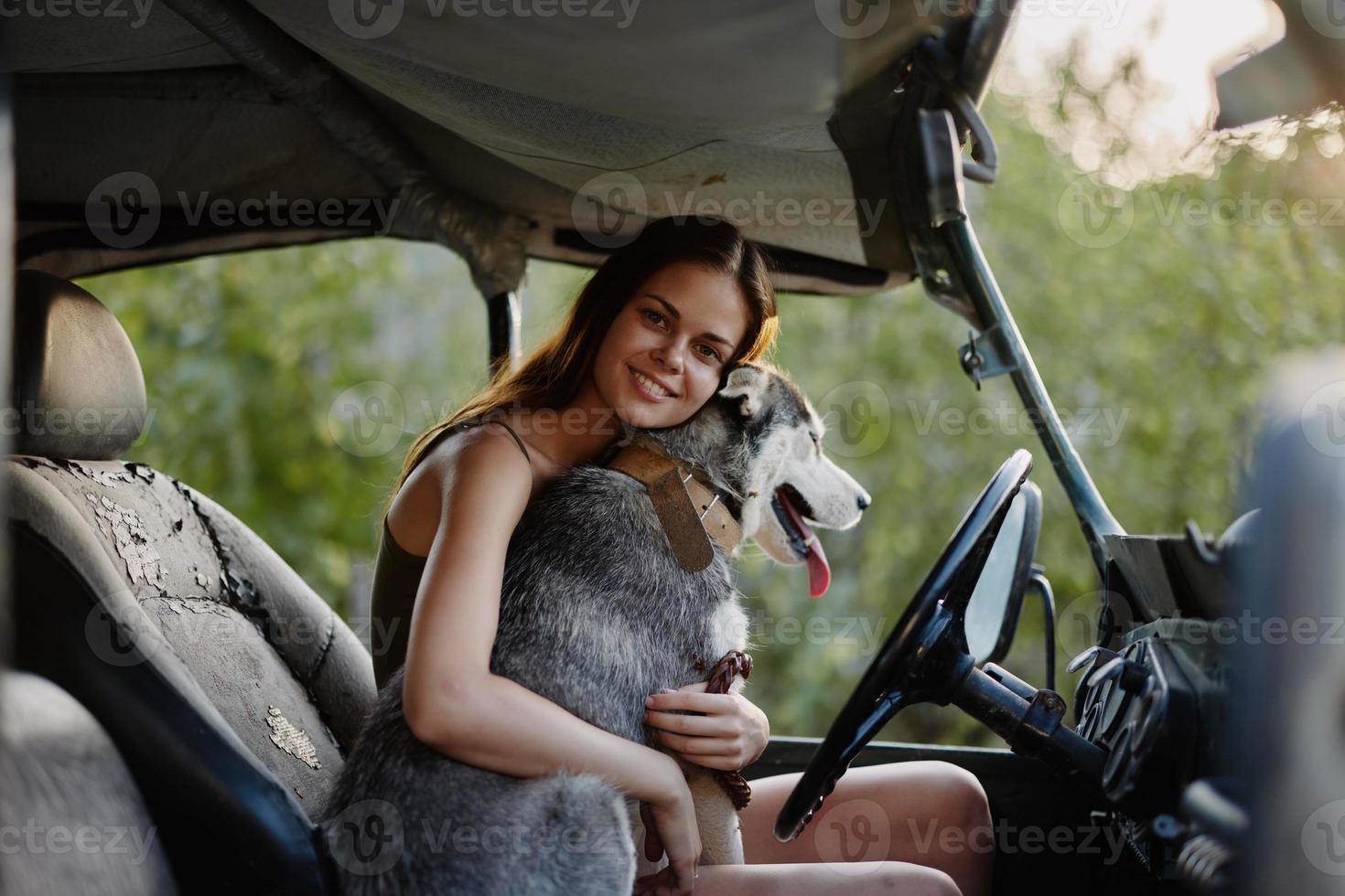 vrouw en schor hond gelukkig op reis in auto glimlach met tanden vallen wandelen met huisdier, reizen met hond vriend knuffels en dansen foto