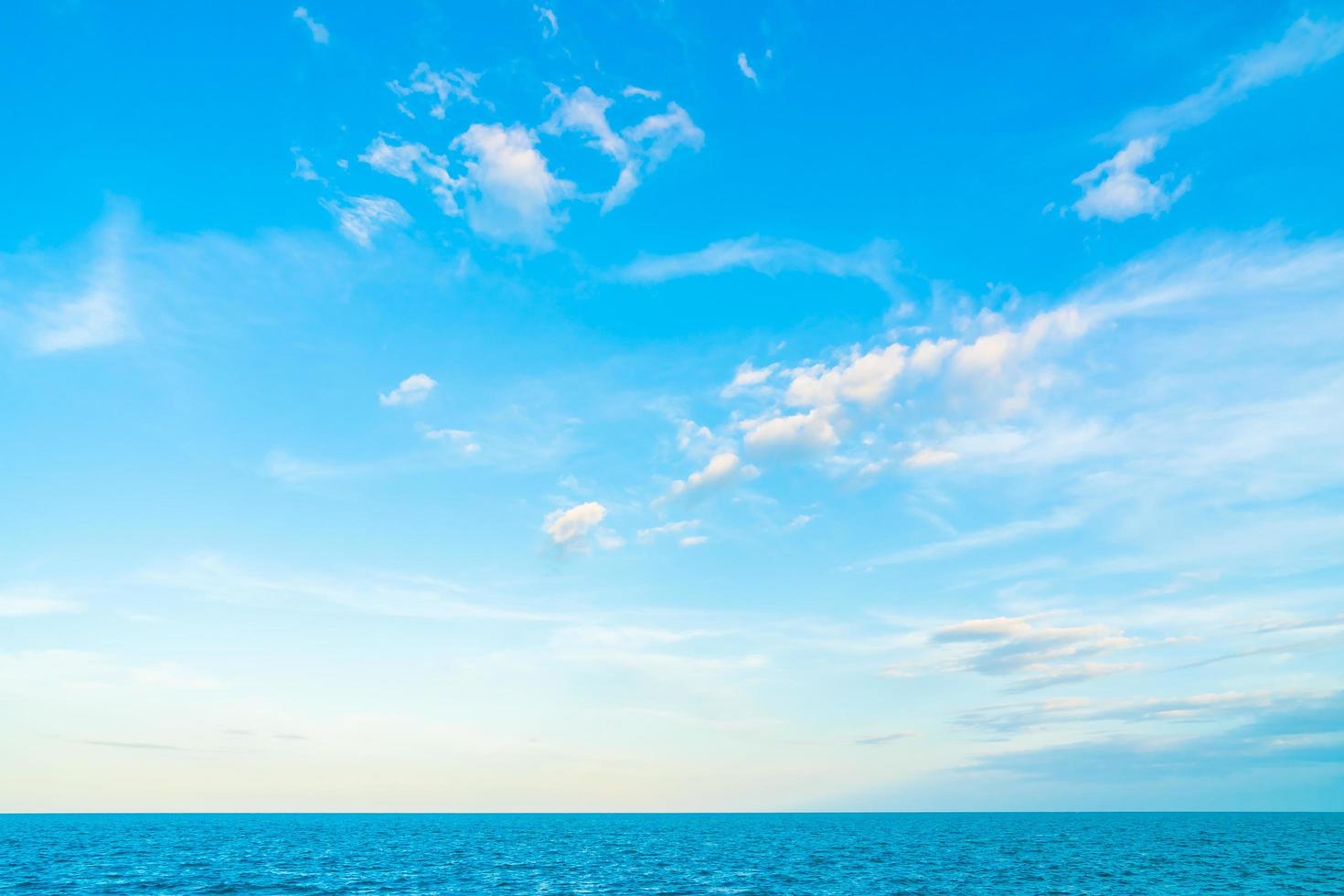 witte wolken op blauwe hemel boven de oceaan foto