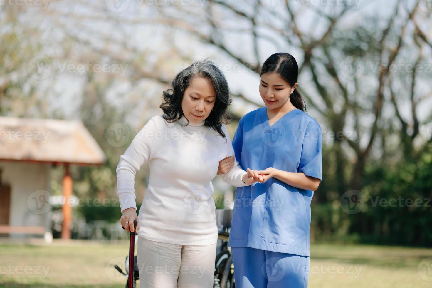 ouderen Aziatisch senior vrouw Aan rolstoel met Aziatisch voorzichtig verzorger. verpleging huis ziekenhuis tuin concept. foto