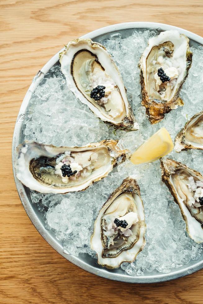 rauwe en verse oester met kaviaar erop en citroen foto