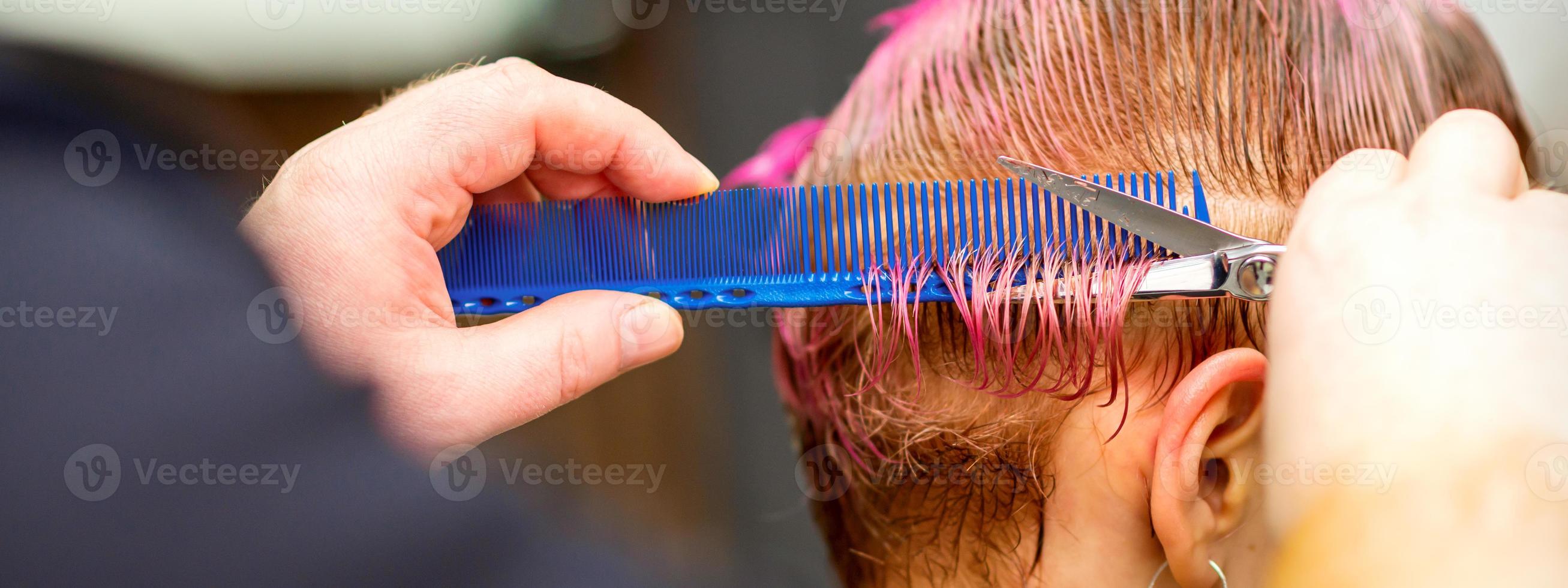 vrouw met roze haar- krijgen kort kapsel foto