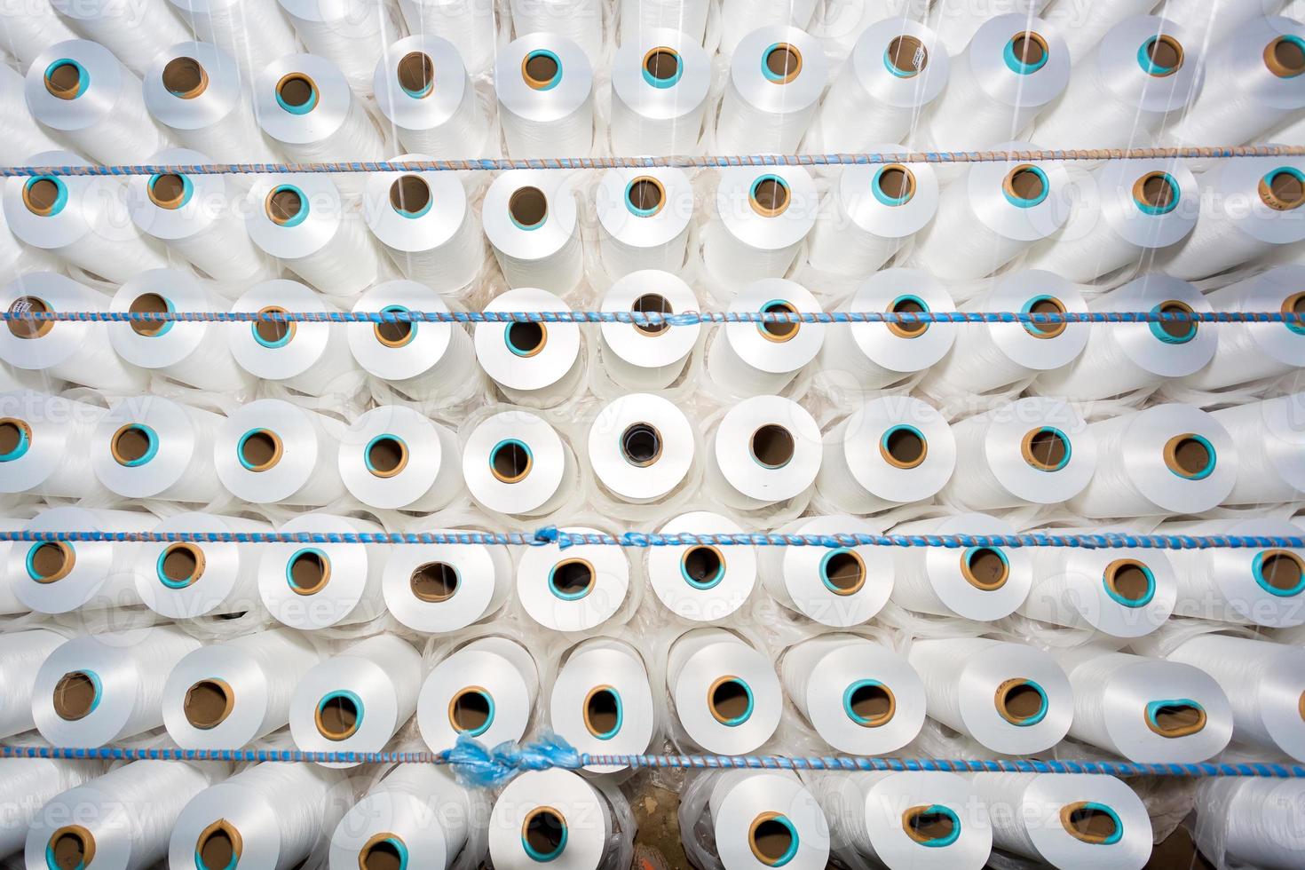 top visie van een veel van wit garen spoelen in een textiel fabriek. wit garen spoelen in een kleding fabriek. foto