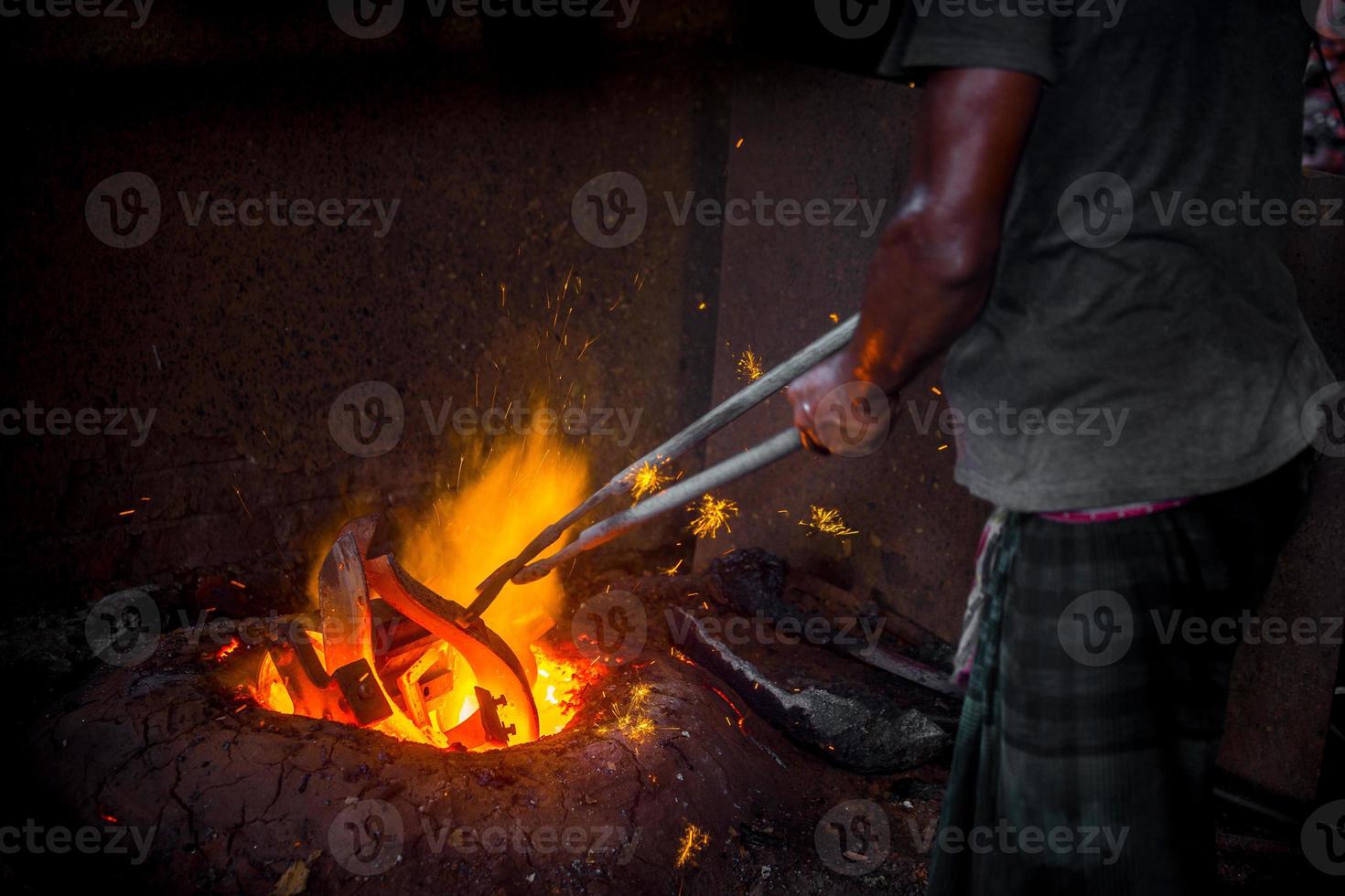 onveilig arbeider handen. een lokaal staal machine onderdelen maken werf arbeider smelten vodje Aan heet oven. foto