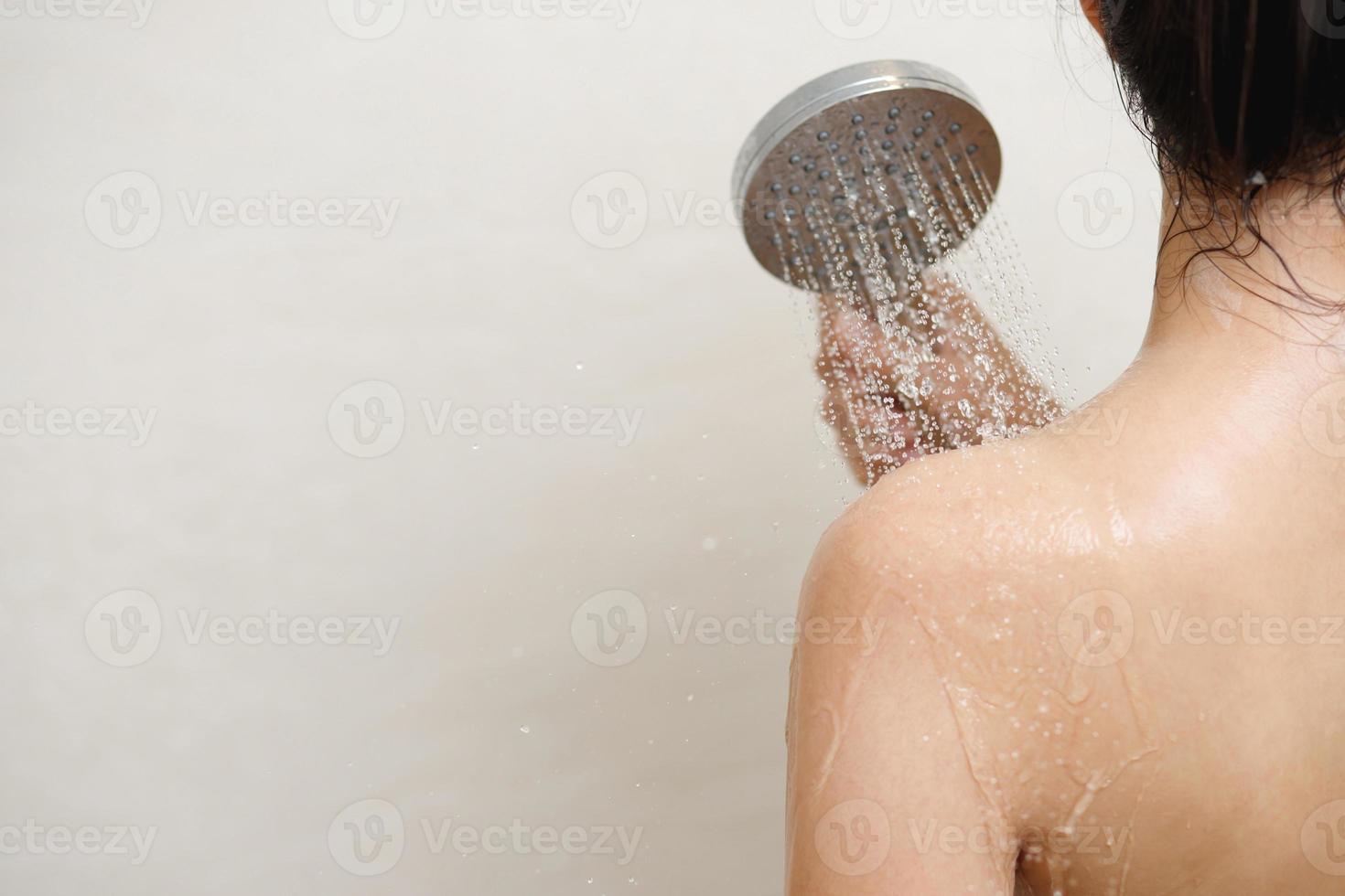 vrouw nemen douche en het wassen haar- met shampoo foto