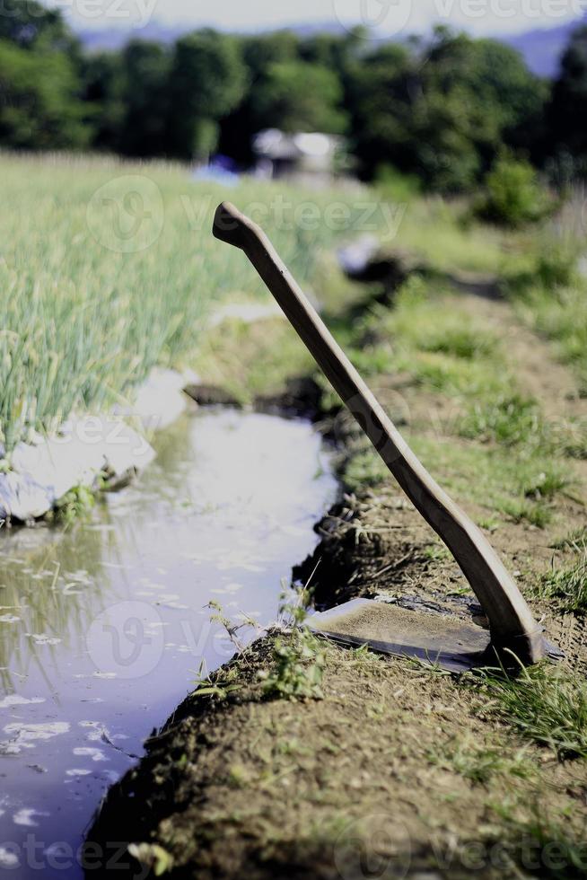 schoffel Bij de rand van de tuin langs een klein stroom gedurende de dag foto