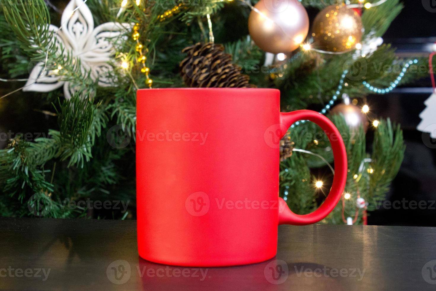 blanco rood mok met Kerstmis boom Aan achtergrond, mat thee of koffie kop met Kerstmis en nieuw jaar decoratie, verticaal bespotten omhoog met keramisch mok voor heet drankjes, leeg geschenk afdrukken sjabloon foto