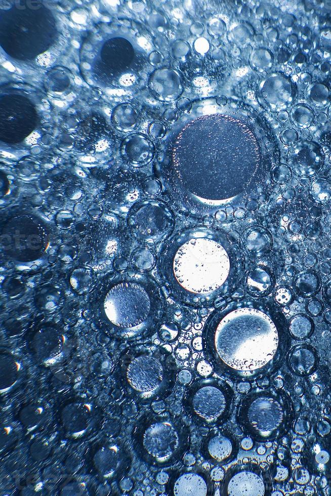 abstract licht blauw achtergrond met olie cirkels . bubbels van water dichtbij omhoog . olie bubbels in de water macro. cirkel bubbels achtergrond foto