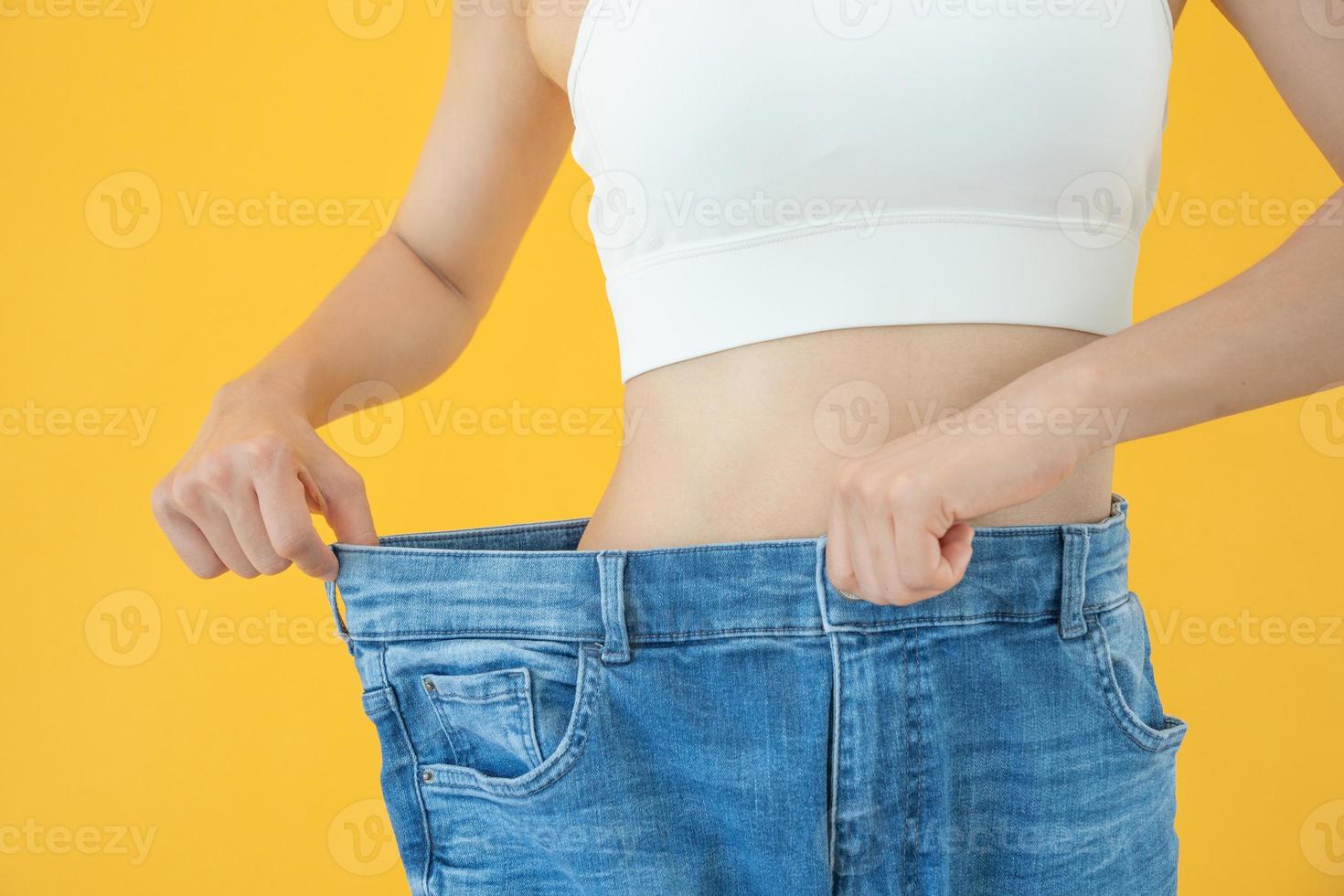 Dames tonen resultaten van eetpatroon. mooi vorm geven aan. vrouw hebben een verminderd taille grootte na onder gaan een gewicht verlies corse. kan niet slijtage jeans ten gevolge naar gewicht verlies. evenwicht, controle, routines, oefening. foto