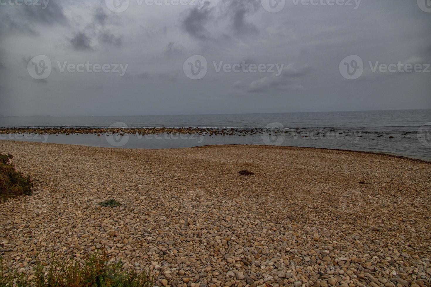 landschap leeg rotsachtig strand Aan een bewolkt dag Spanje foto