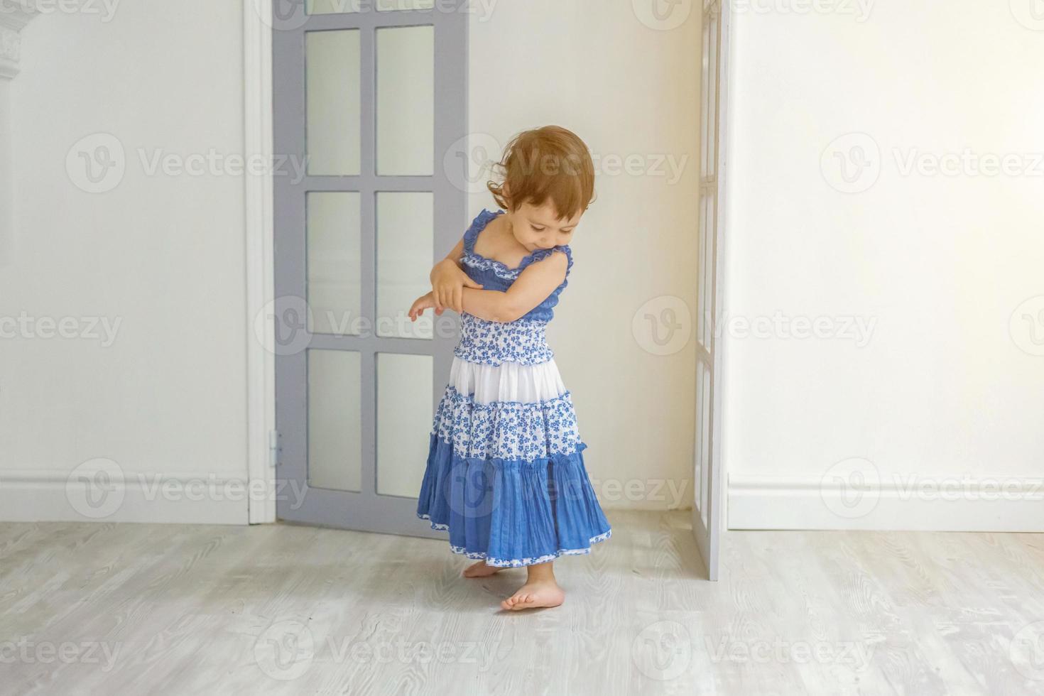 weinig meisje dansen in helder licht leven kamer Bij huis en lachend foto