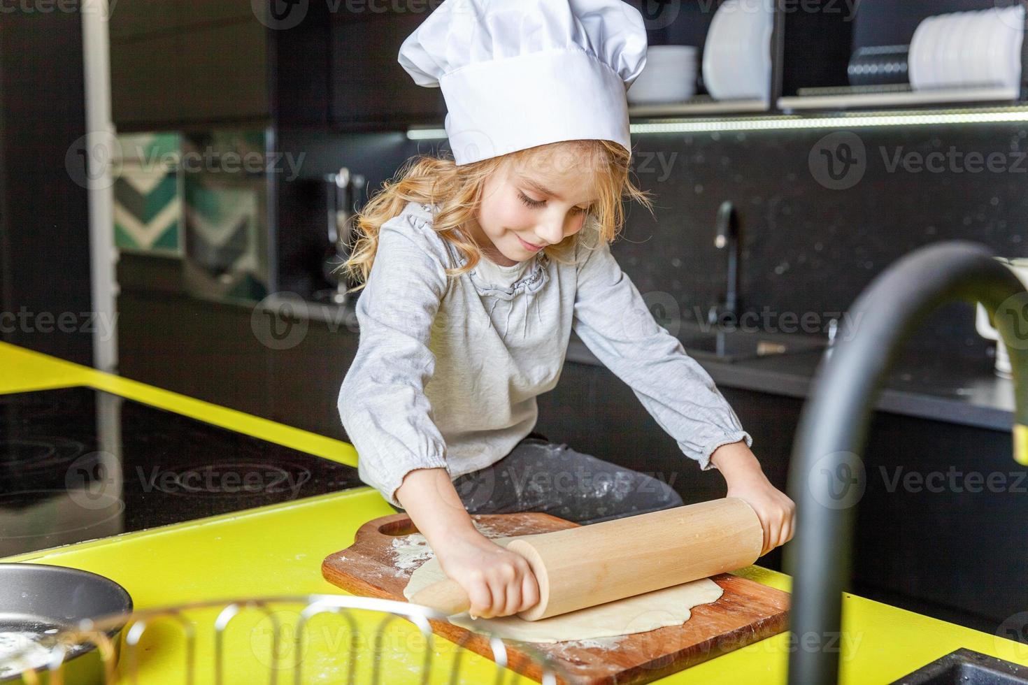 weinig meisje voorbereidingen treffen deeg, bakken eigengemaakt vakantie appel taart in keuken foto