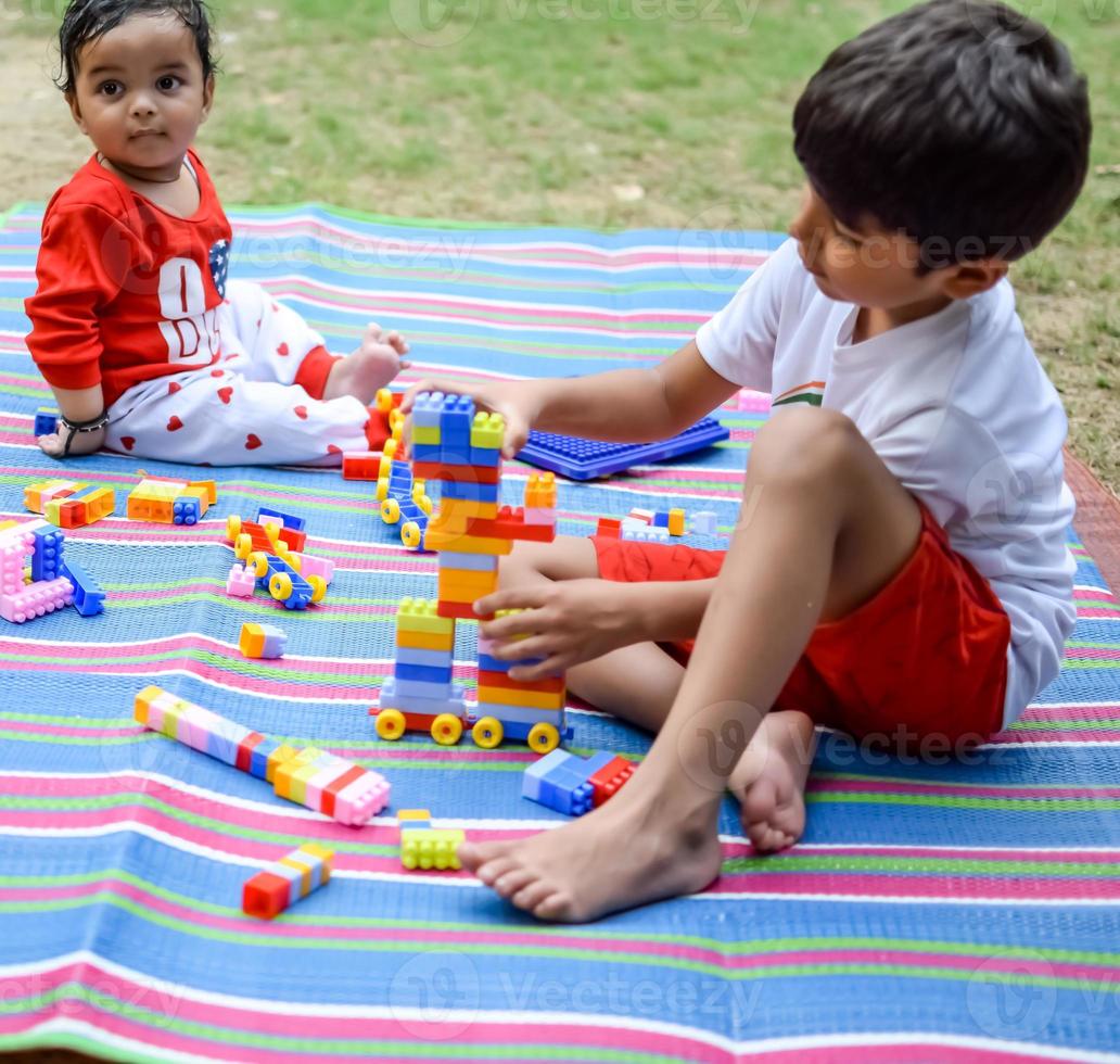 twee gelukkig jongens in maatschappij park, gelukkig Aziatisch broers wie zijn glimlachen gelukkig samen. broers Speel buitenshuis in zomer, het beste vrienden. kleuter baby jongen spelen met zijn gelukkig broer in de tuin foto