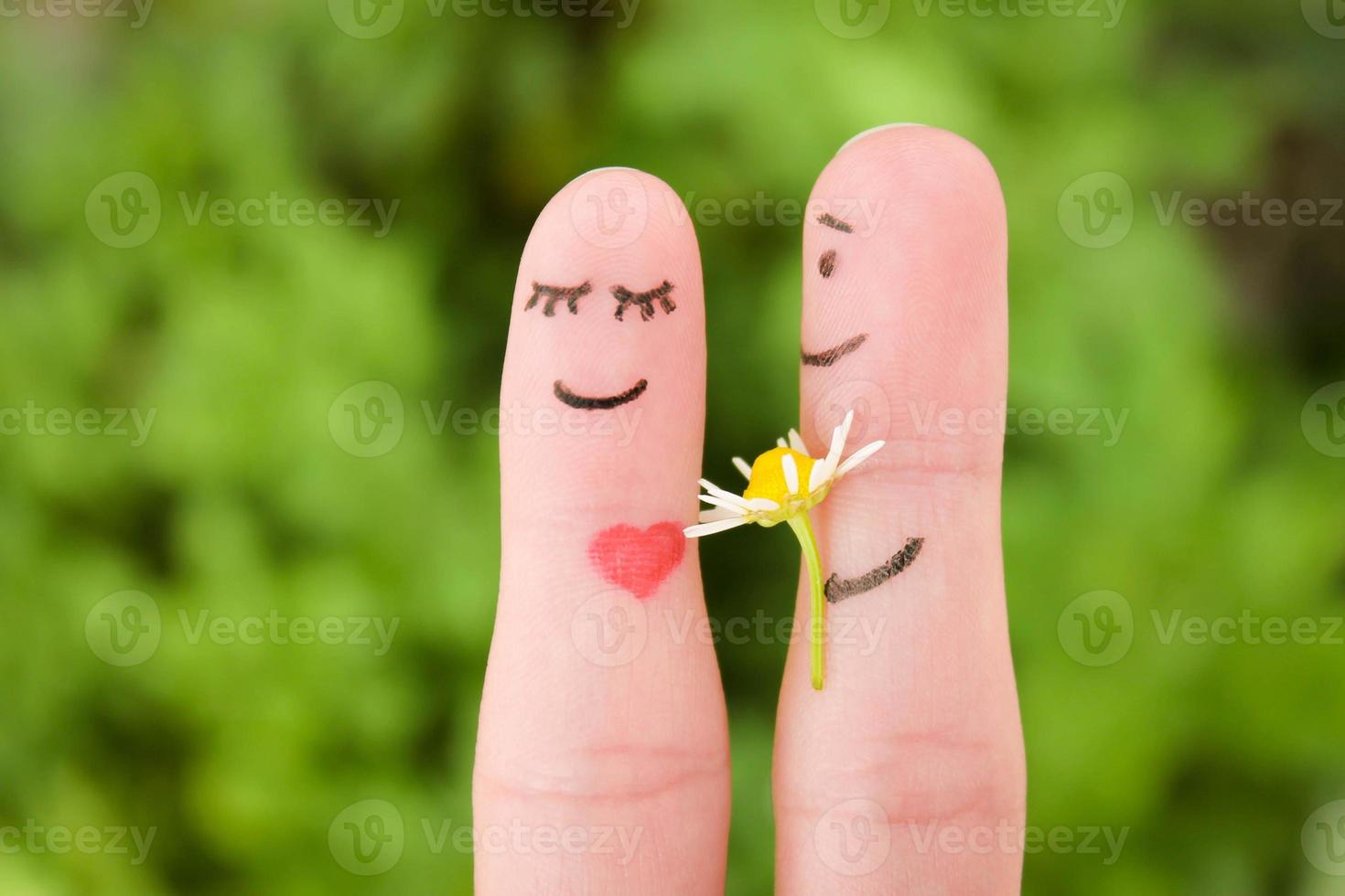 gezicht geschilderd Aan vingers. Mens is geven bloemen naar een vrouw. foto
