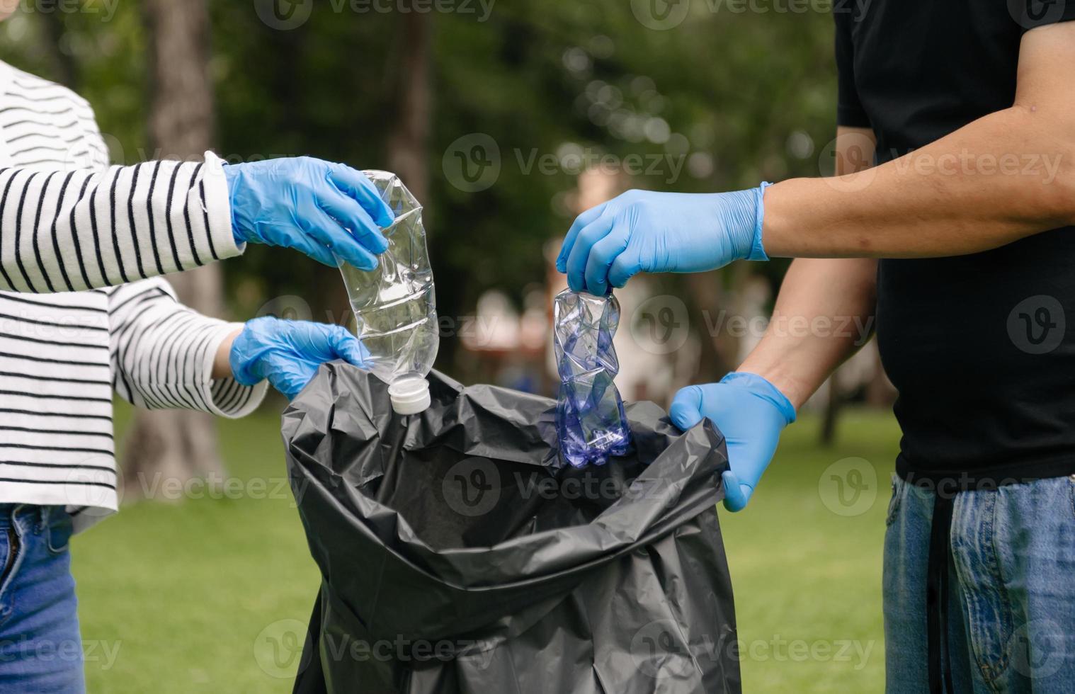 vrouw hand- picks omhoog plastic verspilling voor schoonmaak in recycle zak voor opruimen de park. opruimen, vervuiling, ecologie concept. foto