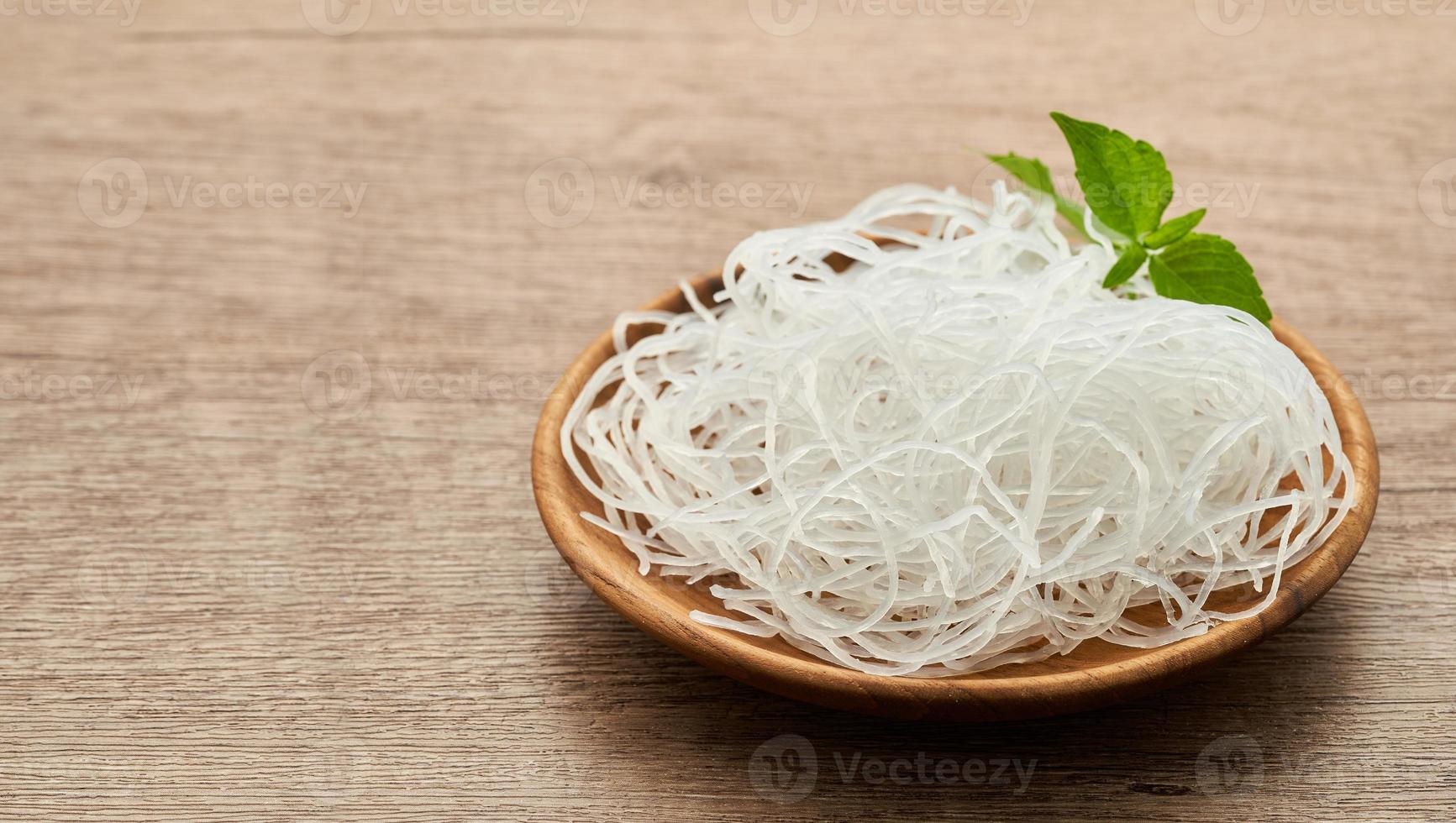 Aziatisch vermicelli of cellofaan noodle in houten bord Aan hout tafel achtergrond. glas noodle foto