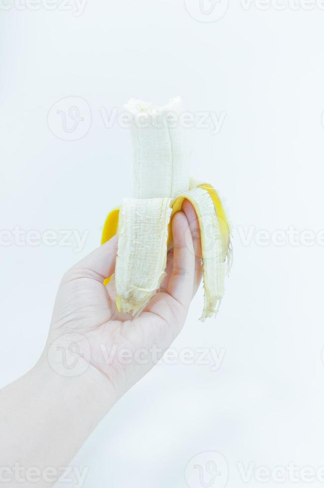 de geschild banaan in een vrouw hand- Holding Aan wit achtergrond, banaan fruit foto