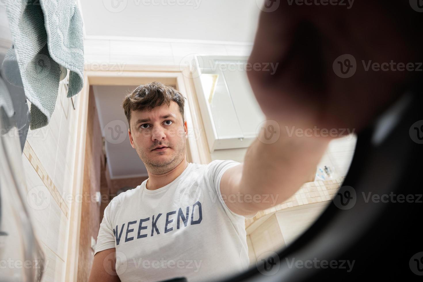 Mens visie van het wassen machine binnen. mannetje doet wasserij dagelijks routine. foto