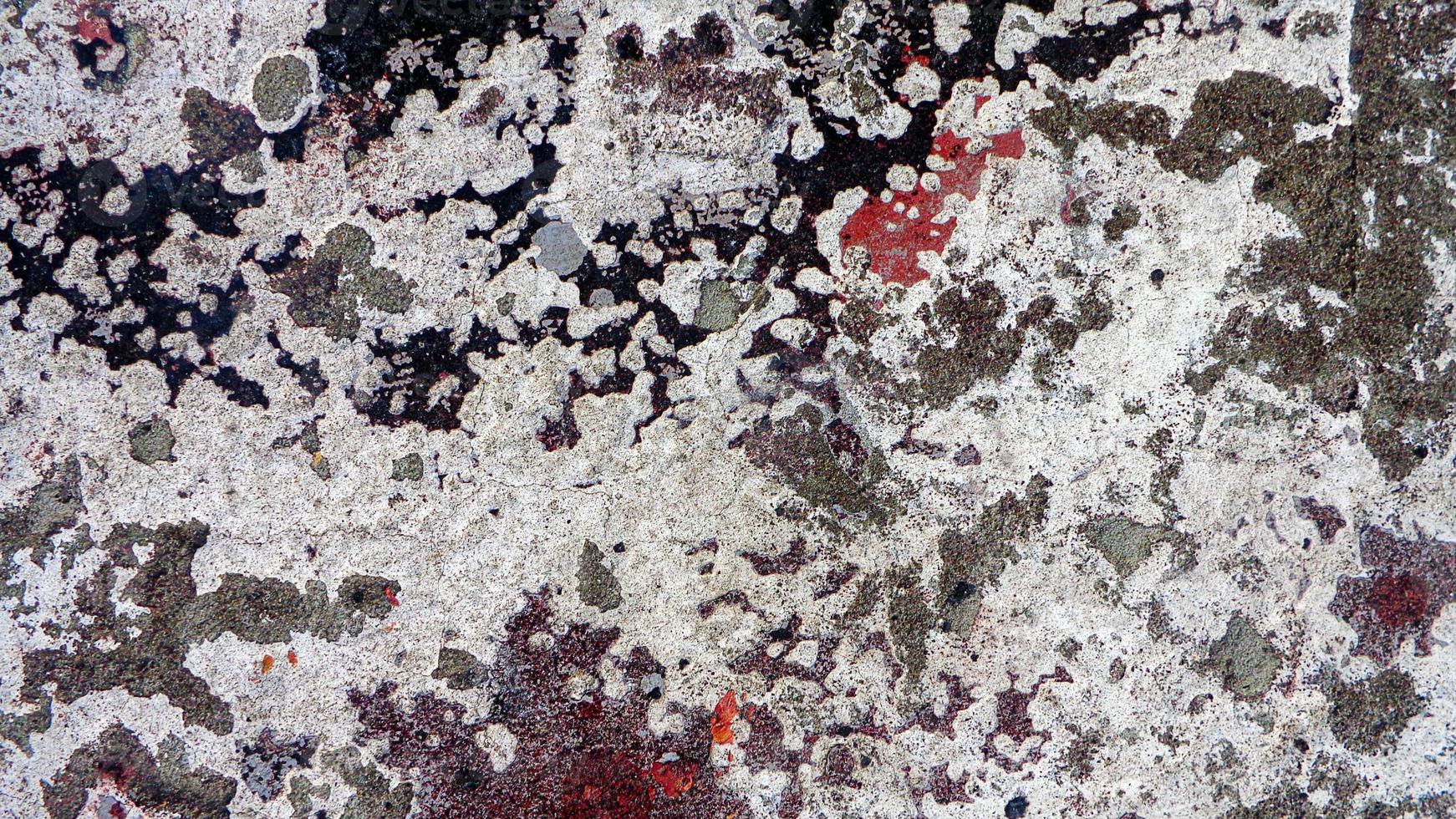 vuil steen muur structuur met vlekken van zwart, grijs en rood haveloos verf foto