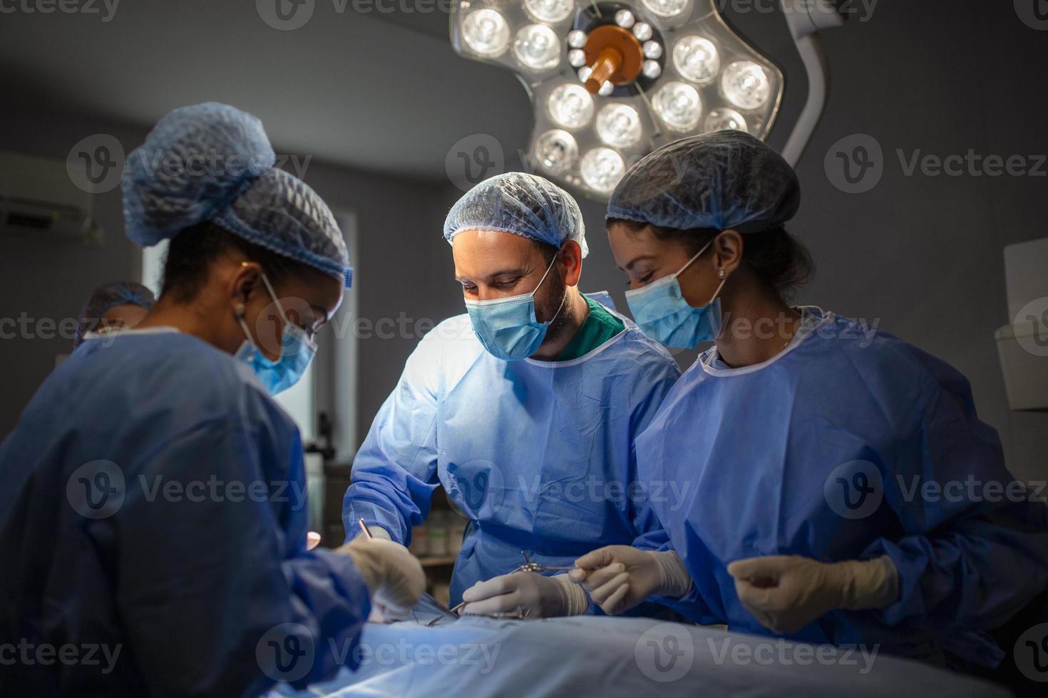 chirurgen het uitvoeren van operatie in operatie theater. borst vergroting chirurgie in de in werking kamer chirurg gereedschap implantaat. medisch zorg concept. foto