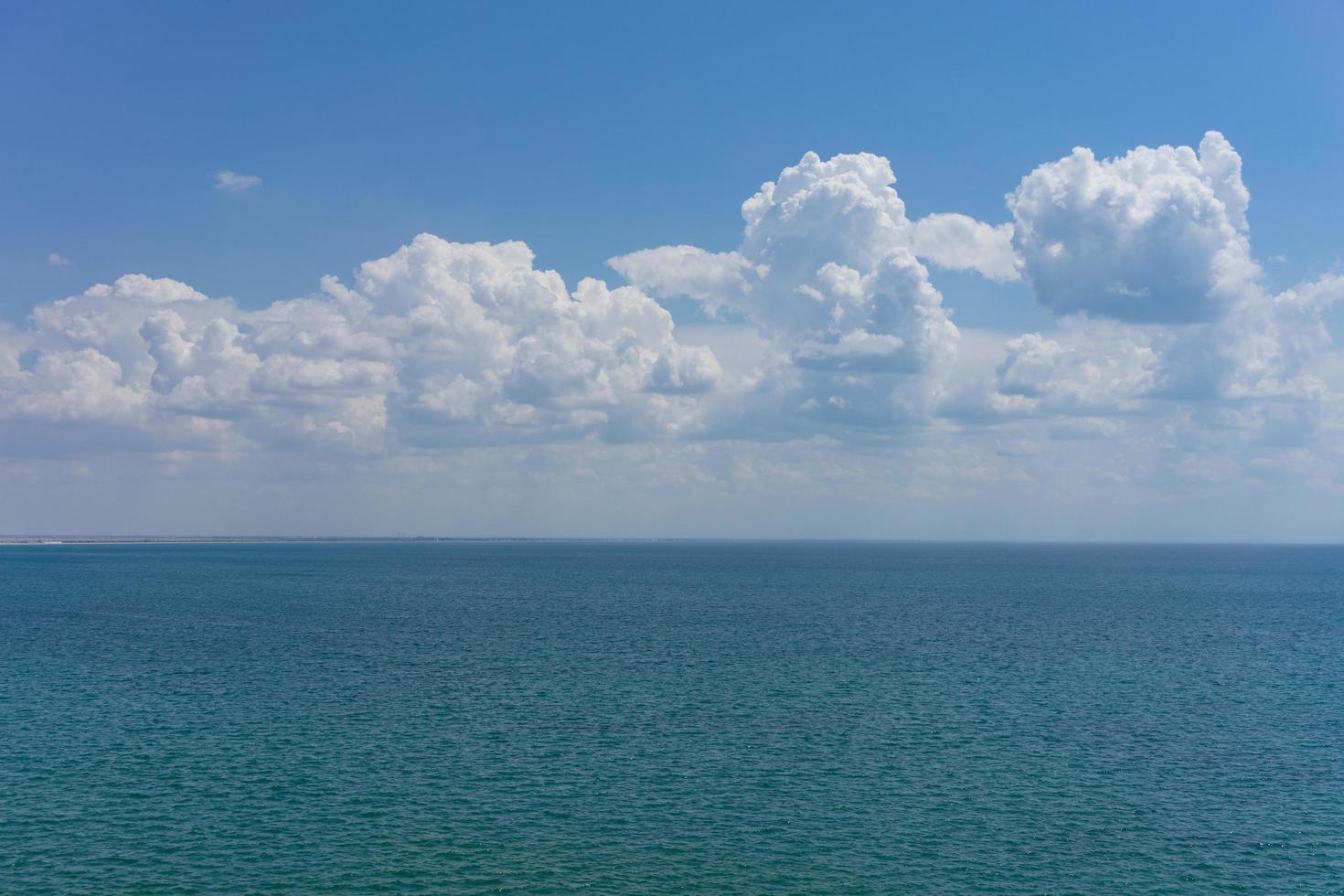 zeegezicht van waterlichaam en lucht met gezwollen witte wolken foto