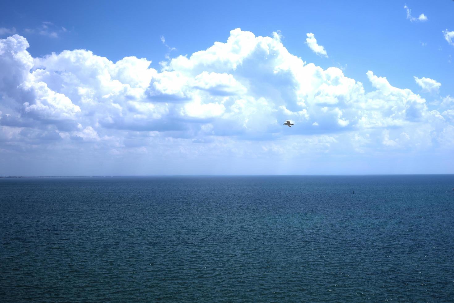 zeegezicht van waterlichaam en lucht met gezwollen witte wolken foto