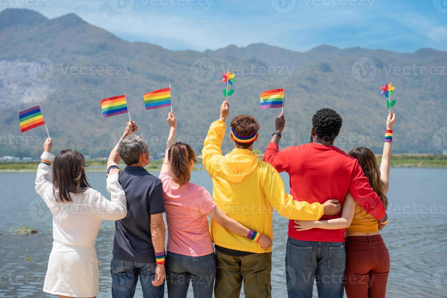 terug visie. jong verscheidenheid mensen Holding homo trots regenboog vlag Aan de strand tegen de lucht. liefde moment uitgeven mooi zo tijd samen. lgbtq concept foto