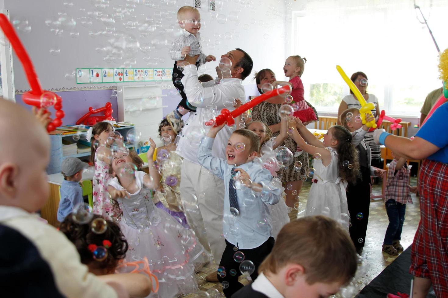 . pret vakantie met kinderen en ouders met ballonnen en zeep bubbels. foto