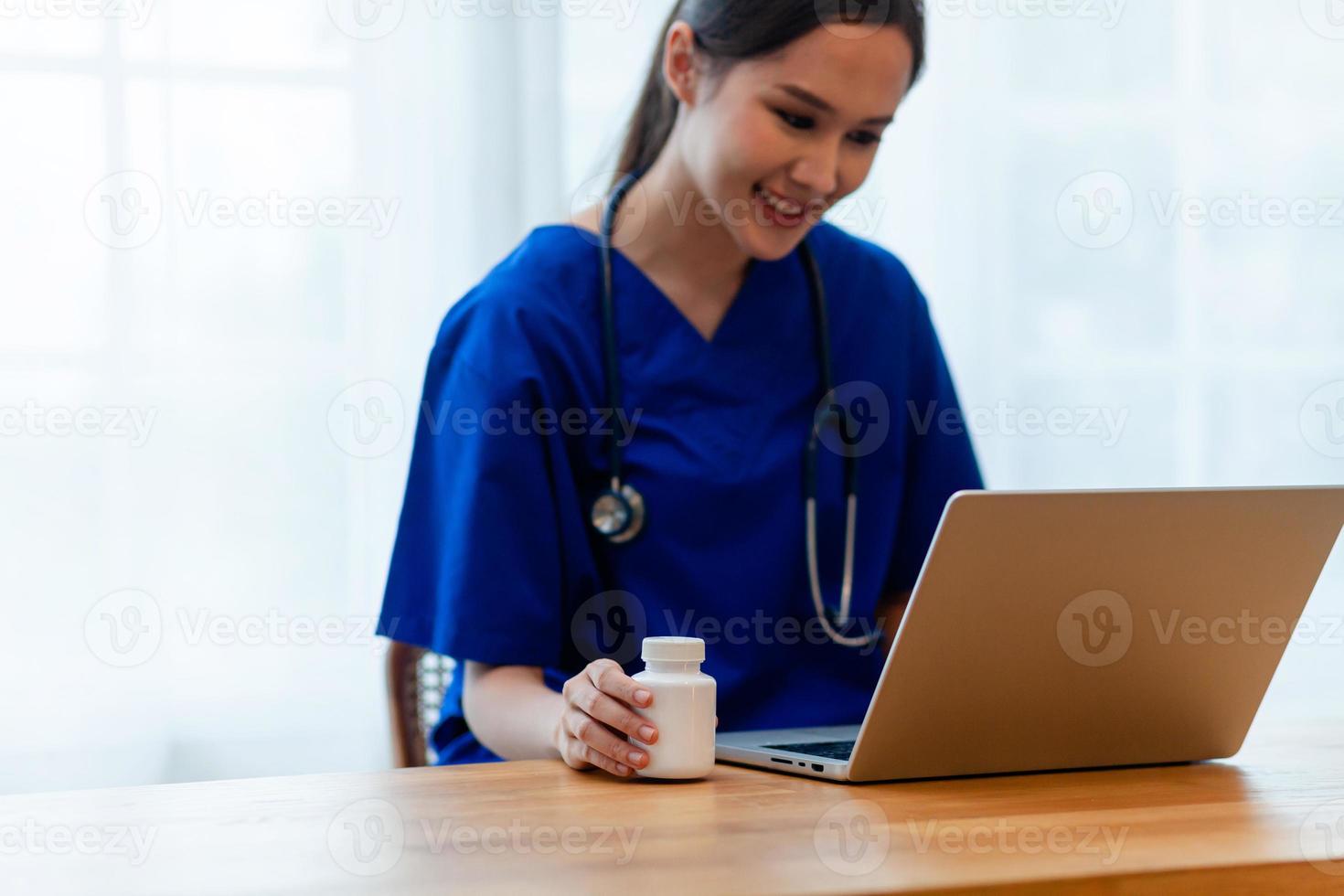 detailopname. Aziatisch verpleegster vol vertrouwen werken Aan laptop in kliniek. gelukkig dokter of verpleegster in ziekenhuis foto