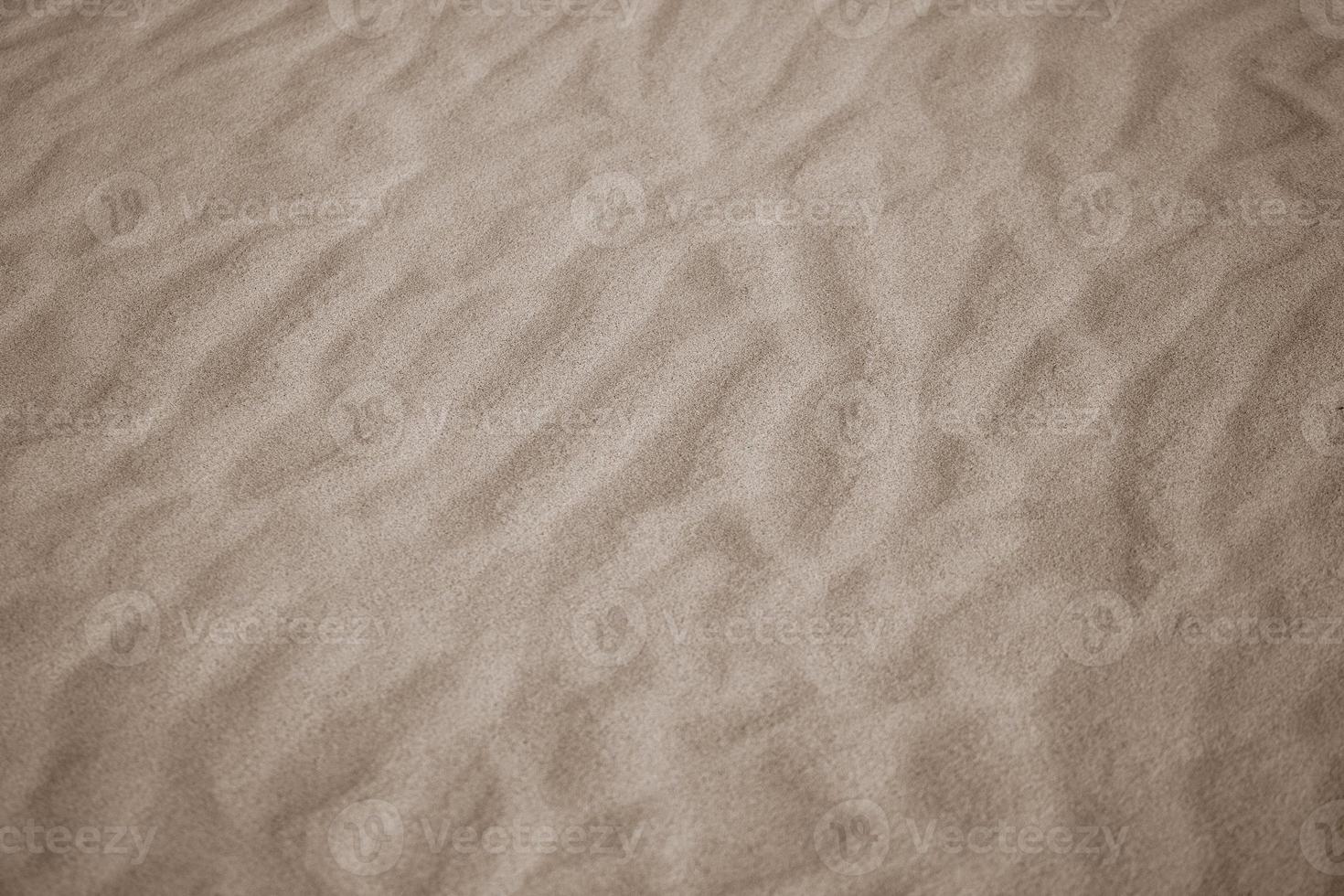 beige achtergrond met zand in de vorm van zand golven foto