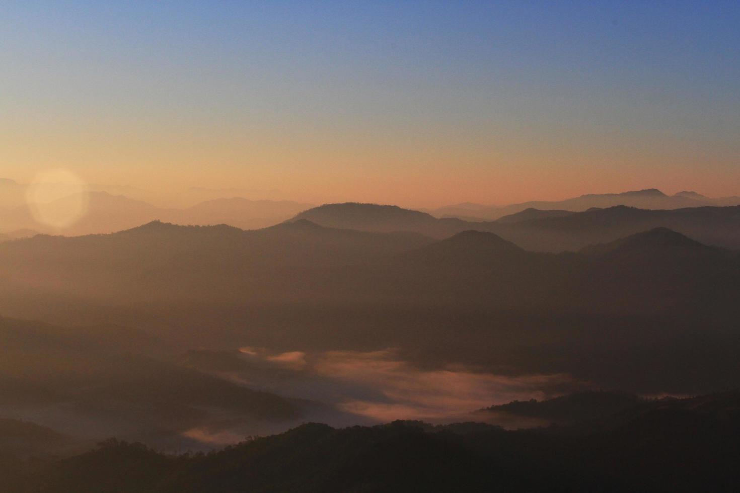 mooi gouden natuurlijk zonlicht en schemering van zonsopkomst schijnend naar in de de nevel Aan vallei van berg in Thailand foto