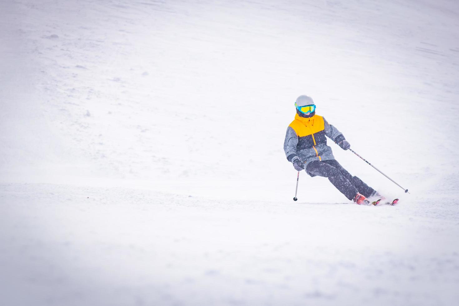 lage hoek vooraanzicht mannelijke persoon alleen skiën bergafwaarts foto