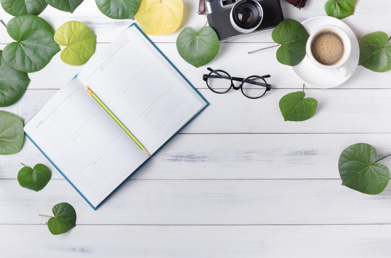 blanco kalender met hart vormig groen blad en koffie foto