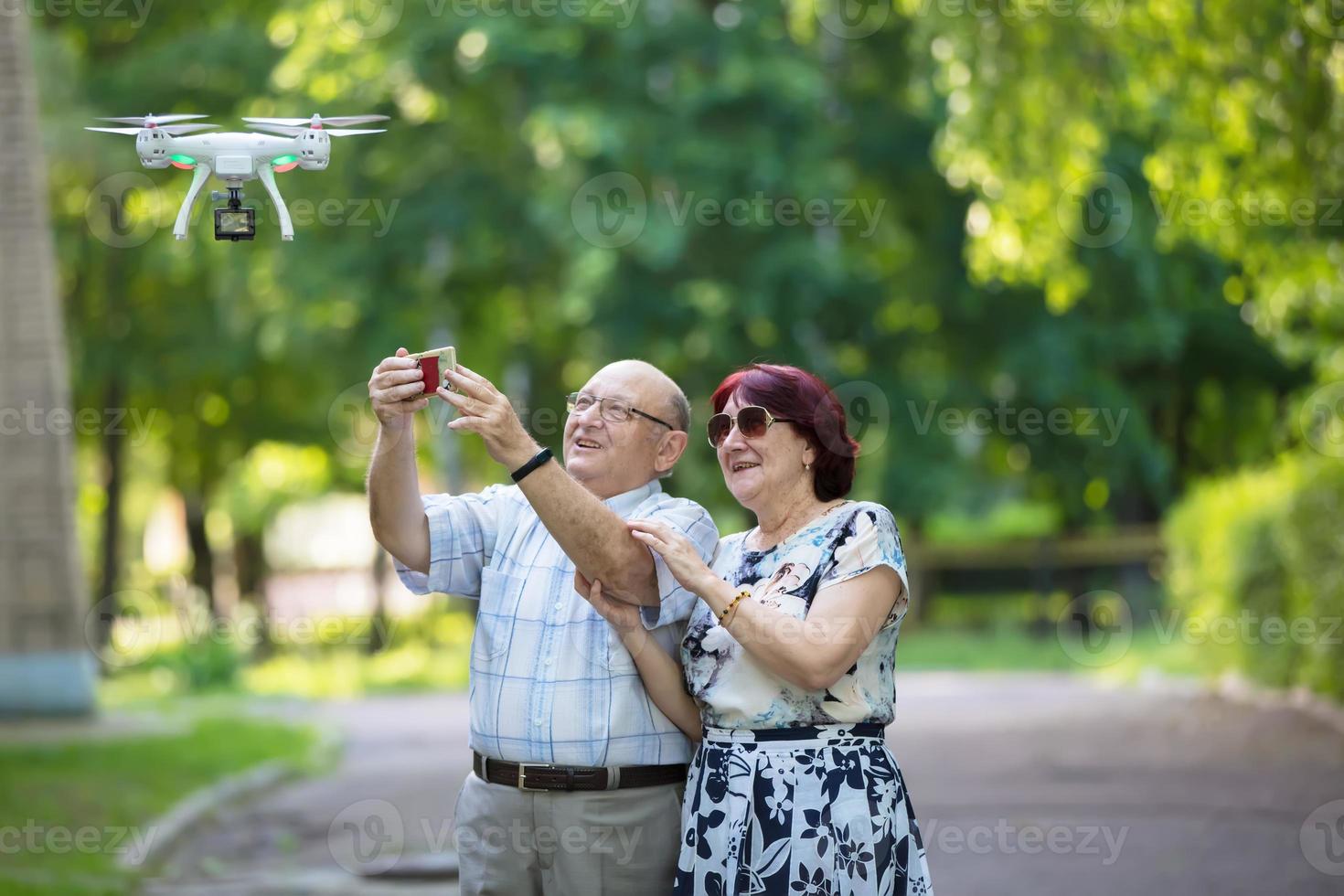 gelukkig ouderen paar Aan een wandelen. ouderen man en vrouw met een drone. liefhebbend echtgenoten in volwassenheid. foto