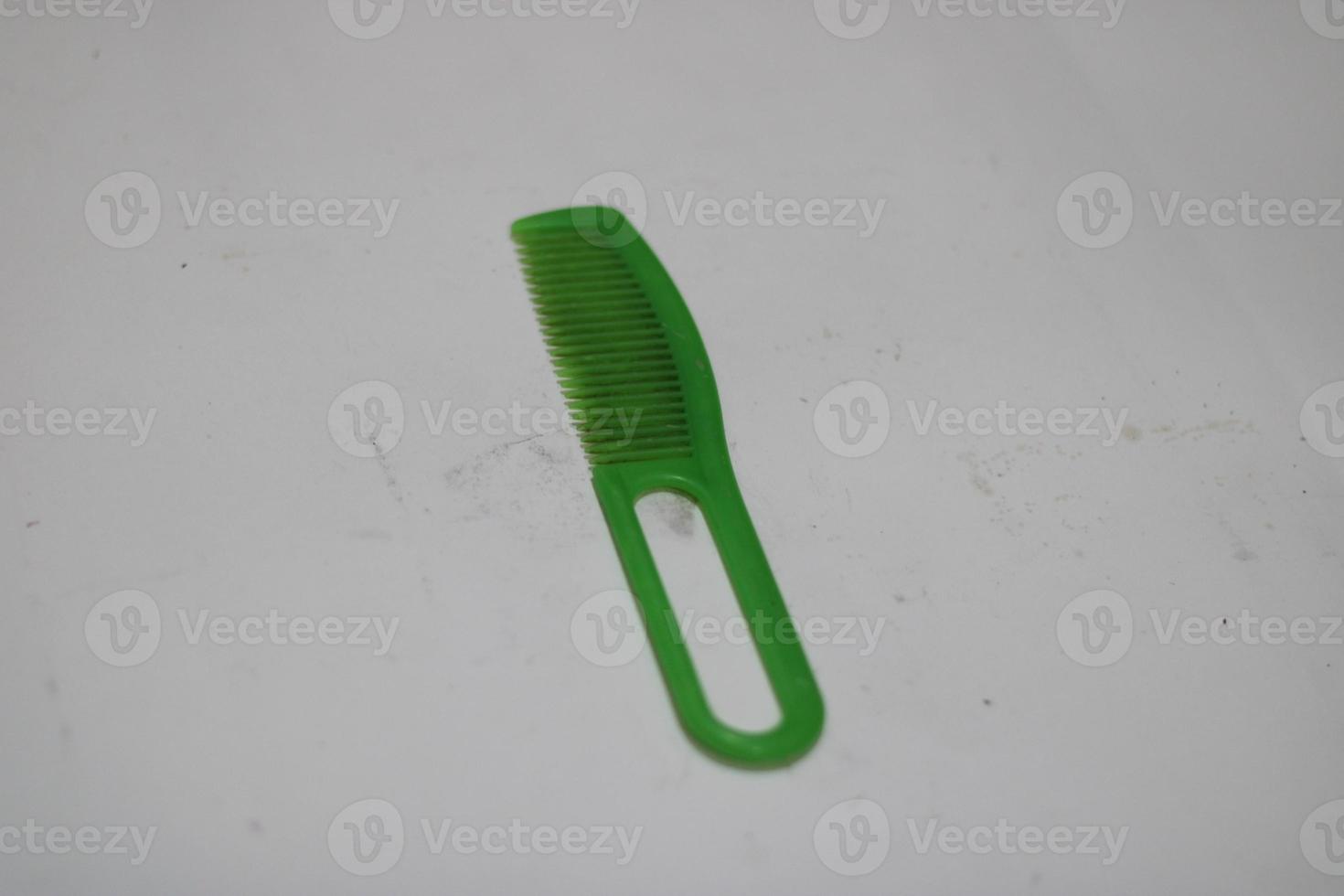 foto van een groen haar- kam gemaakt van plastic met een wit achtergrond