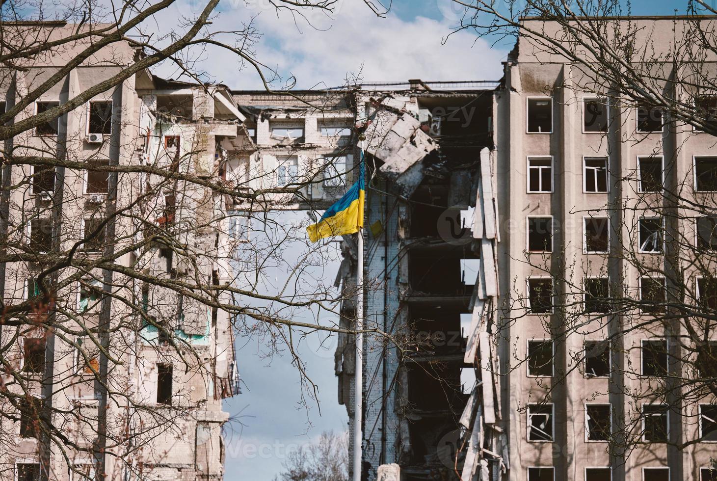 vlag van Oekraïne tegen de achtergrond van een vernietigd gebouw in Oekraïne. de gebouw was vernietigd door een Russisch lucht bom foto