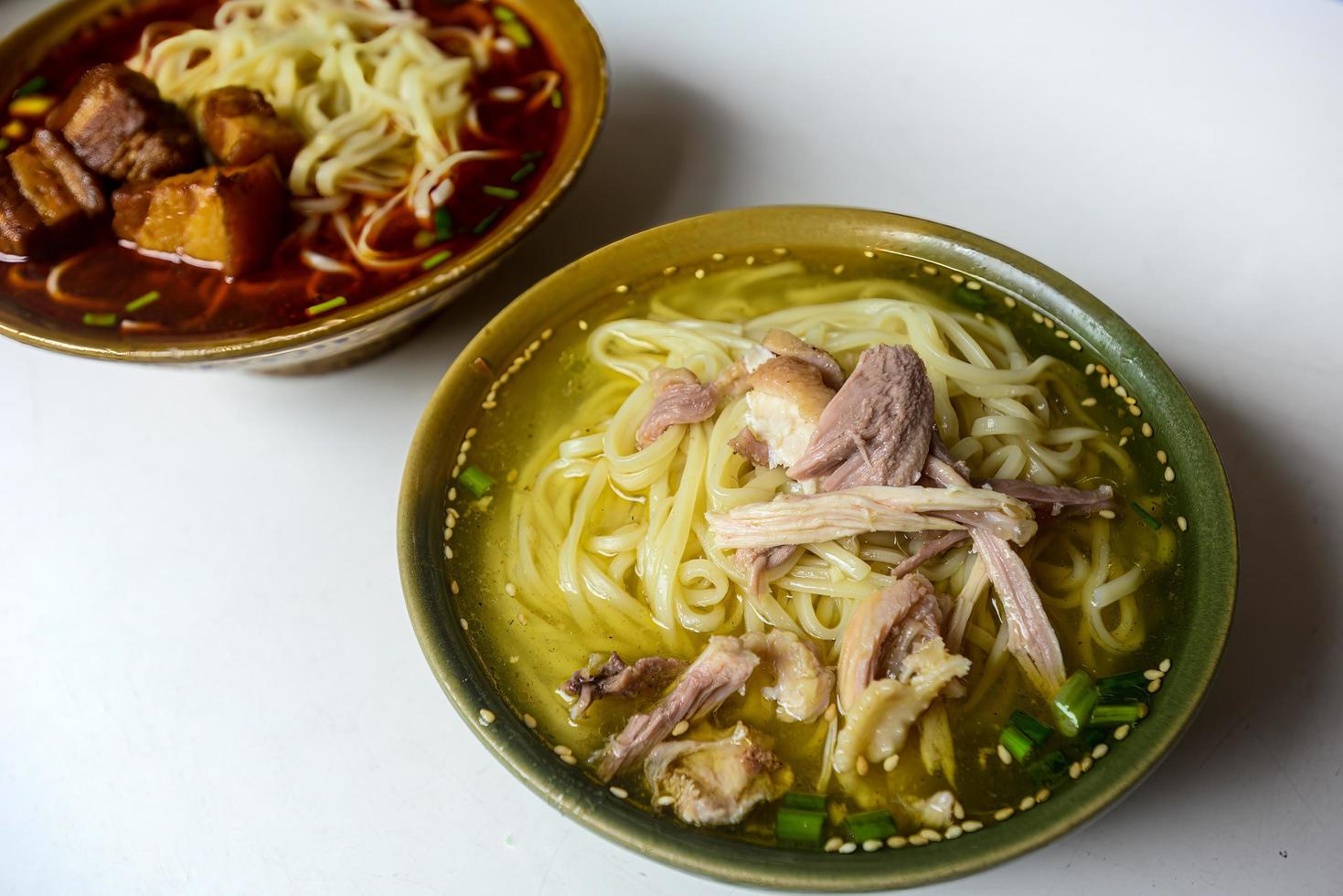 kip noodle soep en gestoofd varkensvlees noedels zijn gemeenschappelijk voedsel in China foto